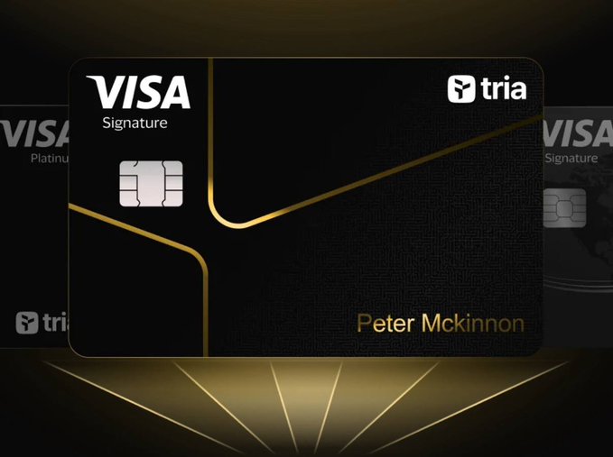 The image features three black Visa cards, each with a gold stripe running down the center of them. The text "Tria" appears multiple times throughout the image, suggesting that these cards are from Tria Bank or a related company. The cards are displayed against a dark background and have a shiny appearance due to their gold stripes. The text "Visa Signature" is also present in the image, indicating that these cards can be used for Visa payments.