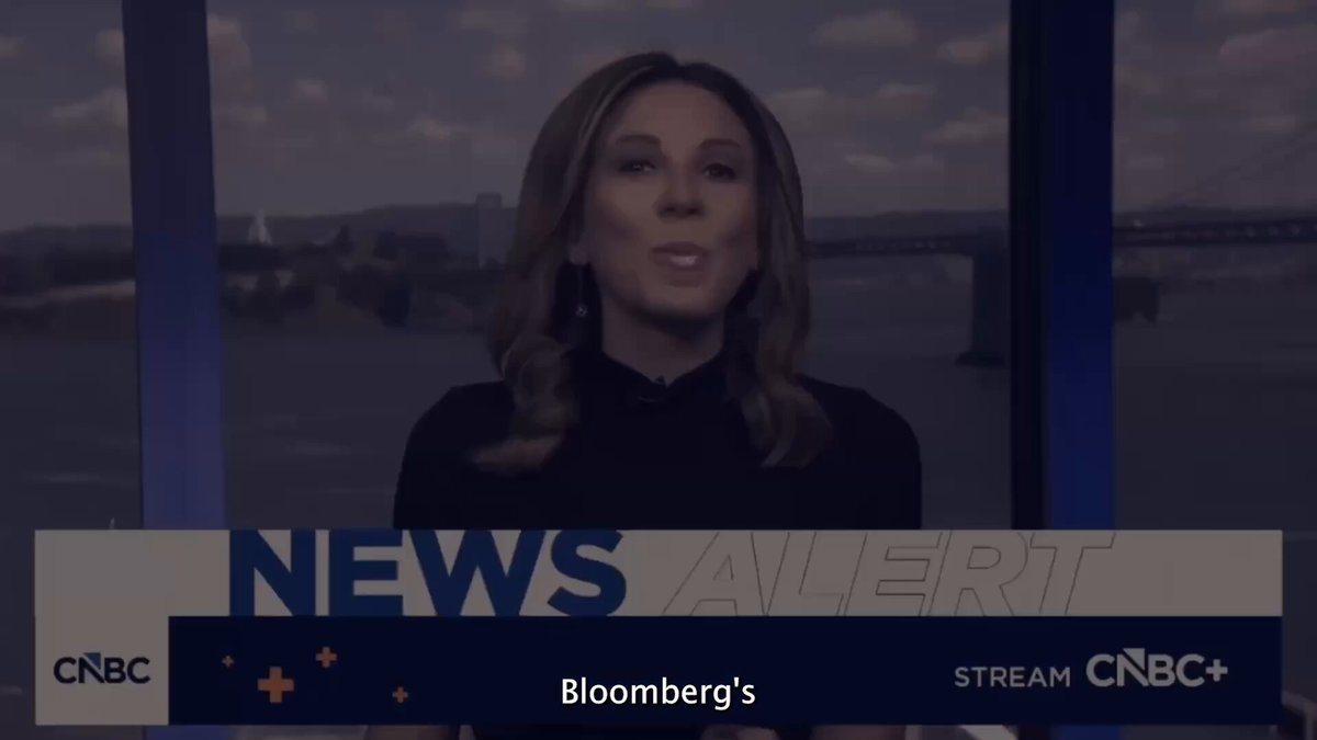 The image shows a news reporter wearing a black shirt, standing behind a desk with a large screen displaying the news. The reporter appears to be talking about the recent news of a SpaceX IPO or an event related to Bitcoin. The text on the screen reads "Crypto Holders - Prepare for SpaceX IPO This Week TimeStamps: 00:00 Michael Saylor AI Liquidity Vacuum 05:52 What'S Next For Bitcoin 06:12".