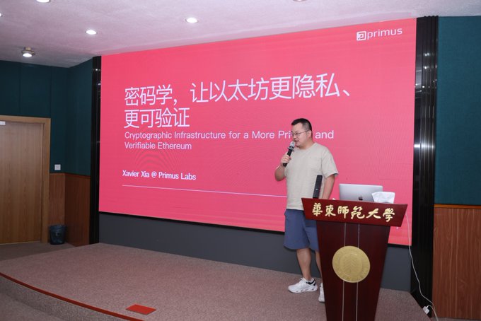 A man gives a presentation at a podium labeled "华东师范大学" (East China Normal University). The screen behind him displays a slide titled "密码学，让以太坊更隐私、更可验证" (Cryptographic Infrastructure for a More Private and Verifiable Ethereum) by Xavier Xia @ Primus Labs.