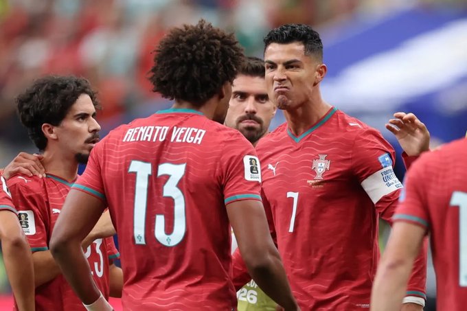 Cristiano Ronaldo (#7) of Portugal's national team is shown in a tense huddle with teammates, including Renato Veiga (#13), wearing their red kits during an international match. The image accompanies news of a $103,000 Polymarket bet on Portugal to beat Colombia, leveraging the visible intensity of Ronaldo and his squad just before kickoff.