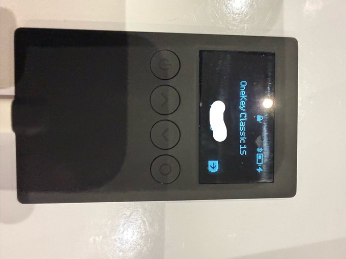 Photo of a small black handheld MP3 player/music device displaying 'Donkey Classic 15' on its screen, lying on a white tiled surface.