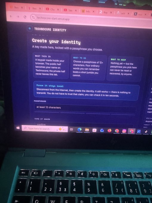 A laptop screen displays the "Technocore Identity" setup page at technocore-start.vercel.app, where users are prompted to "Create your identity" with a passphrase of at least 12 characters to generate their decentralized identifier (DID). The interface explains key concepts and instructs users to disconnect from the internet during creation for security, directly illustrating the first step of the @flop_labs onboarding process.