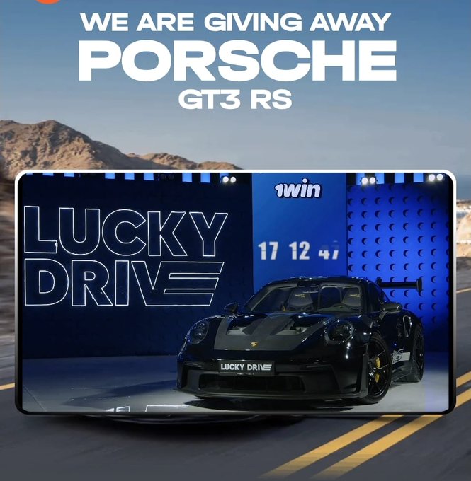 A promotional banner announces "WE ARE GIVING AWAY PORSCHE GT3 RS" above an image of a black Porsche 911 GT3 RS displayed on a stage, with "1win," "LUCKY DRIVE," and the numbers "11 12 41" visible in the background. The advertisement aligns with the post about 1win's giveaway offering free tickets to entrants who deposit $10 or more, with the car serving as the prize centerpiece.