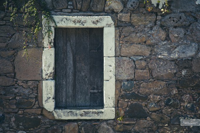 An old wooden door set within a white stone frame embedded in a rugged stone wall, captioned "Where Time Forgets" 1/1 by bxxxxxx, featuring the watermark "Chimera Photografies," evokes a sense of timeless stillness amid the world's motion.