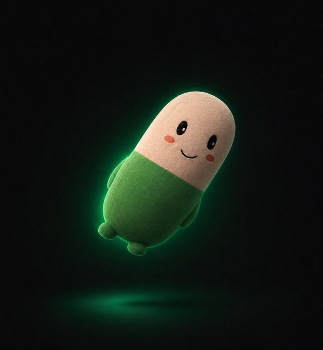 A small, smiling plush toy with a beige cylindrical head and green body floats against a black background with a faint green glow.