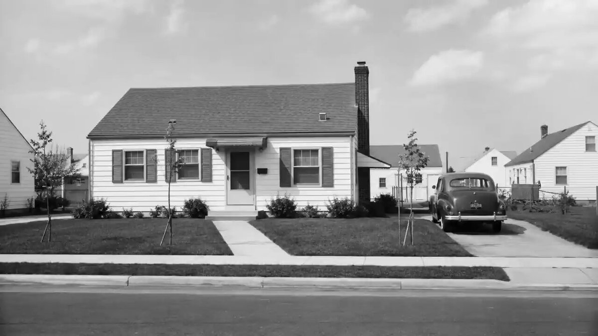 The image shows a house with a car parked outside, possibly an old-fashioned one. The scene appears to be black and white, giving it a vintage feel. The text "Buying XRP in 2026 Is Like Buying Bitcoin in 2010" is present, which seems unrelated to the main subject of the photo - the house and the car. It could potentially be a reference to an article or post about cryptocurrency trading, but its relevance to the image is unclear without additional context.