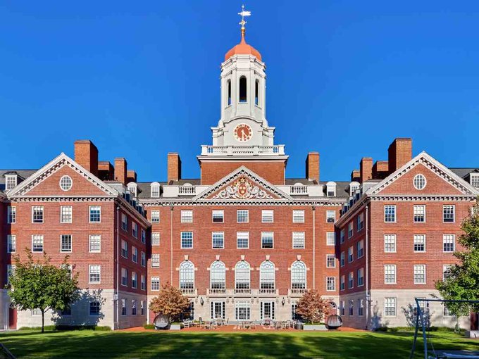 A grand red-brick building with a white clock tower topped by a weather vane stands under a clear blue sky, with "Dunster House" inscribed above the central entrance and "VERITAS" displayed on the central pediment.

The image of a stately Harvard University building is paired with a sensational claim about the institution making a massive $101 million Bitcoin ETF purchase—though such an announcement would be extraordinarily unusual for the university and the image itself provides no actual evidence of any cryptocurrency investment.