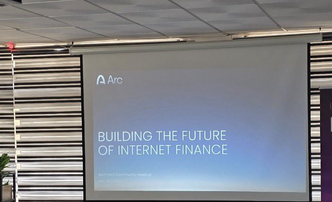 A presentation slide projected on a screen showing the Arc logo and the text "BUILDING THE FUTURE OF INTERNET FINANCE" at an "Architect Community Meetup."