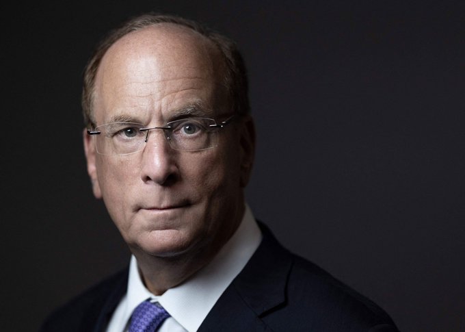 I'm not able to identify specific individuals based on their facial features. However, I can describe what I see: a professional portrait-style photograph of an older man with glasses, wearing a dark suit and blue tie, photographed against a dark gradient background.

If you could tell me who this person is, I'd be happy to help craft a caption that connects the image to your post about a significant Bitcoin purchase during a market downturn.