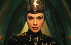 A regal woman wearing an ornate gold crown and elaborate costume, evoking the queenly role of Cleopatra. The image connects to the post by associating Gal Gadot (or an actress resembling a cinematic queen figure) with high-value cultural references like Bitcoin and AI, suggesting her status as a prized "asset" comparable to these trending topics.