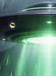 A dark, blurry green-tinted image showing what appears to be a circular structure or portal with a small orange moon-like object visible in the upper left.