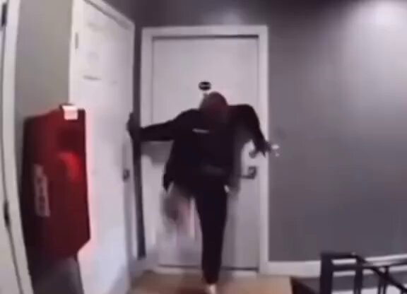 The image shows a person standing in front of an open door, holding a bag with their arms outstretched as if they are about to enter or exit the room. The scene appears to be from a video game, possibly involving a character named "Phantom Wallet" who is playing on someone's computer.