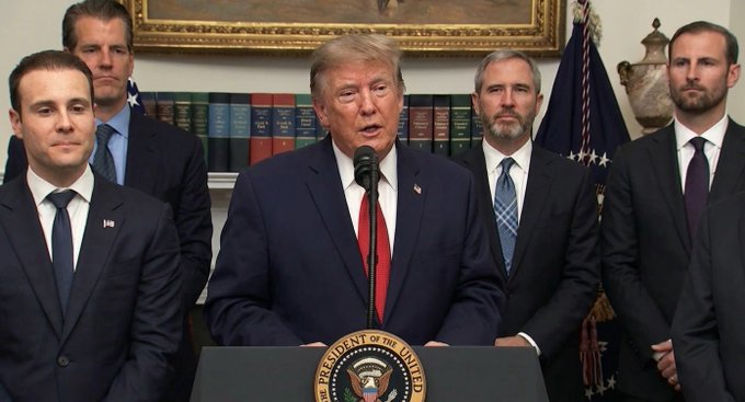 President Donald Trump stands at a podium with several men in suits behind him, implying a connection to $XRP.