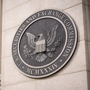 The official bronze seal of the U.S. Securities and Exchange Commission, featuring an eagle with a shield, mounted on a stone building wall.