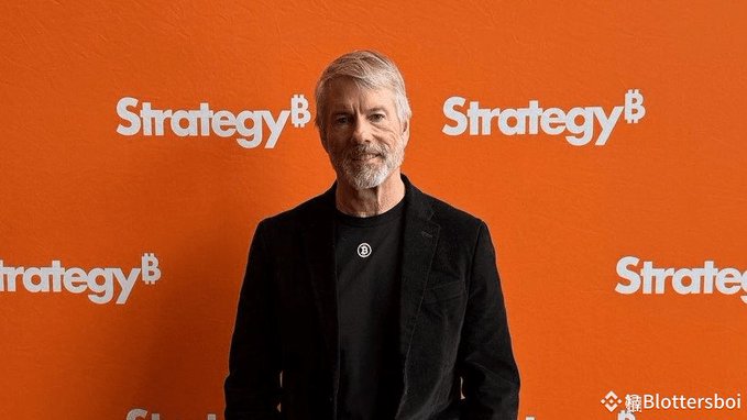 Michael Saylor, founder of Strategy ($MSTR), stands in front of an orange backdrop featuring the company's "Strategy" branding and Bitcoin logo, visually tying him to the company's latest Bitcoin sale announcement.