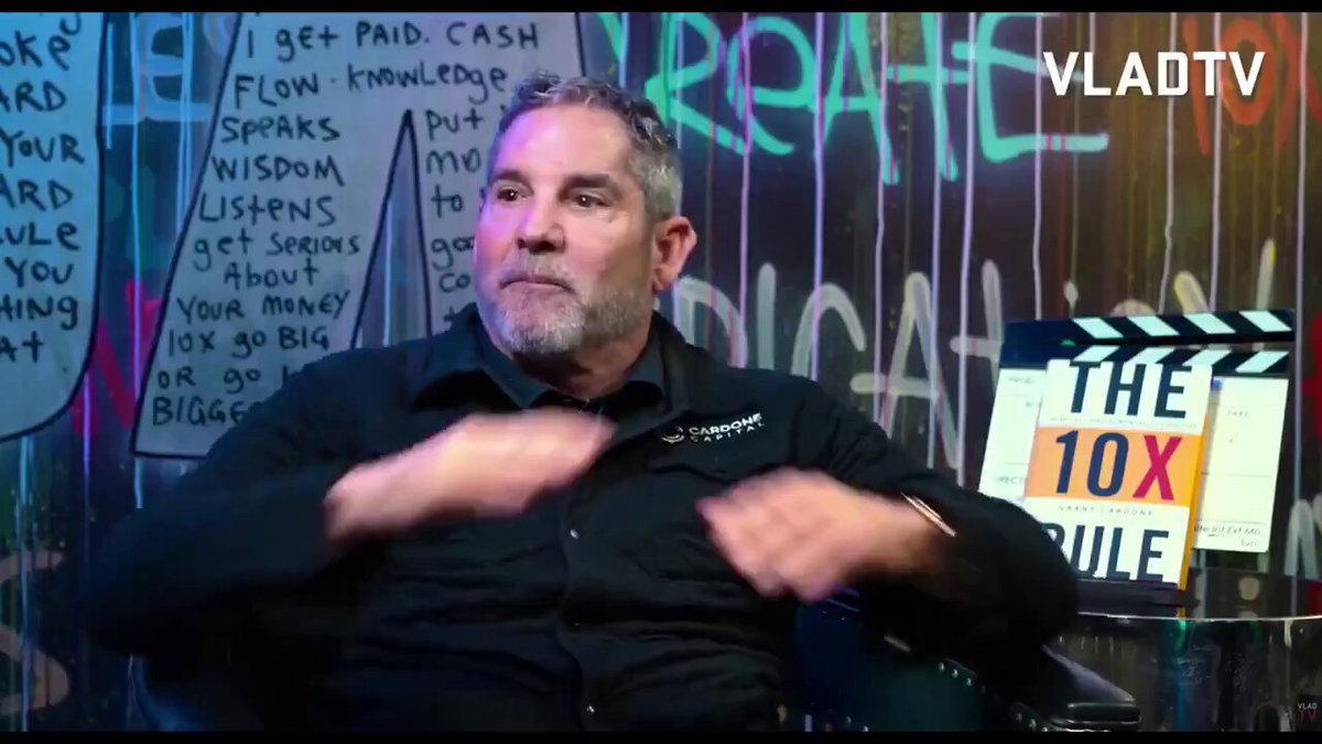 The image features a man sitting down with his hands clapping together. The background behind him has graffiti written on it, which adds an urban feel to the scene. In front of the man, there's a sign that says "The 10X Rule" in white text against a black background. The post also mentions Bitcoin and how it can be used as a form of currency or investment.