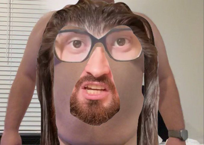 The image features a man with long hair wearing glasses and a beard, who appears to be wearing a mask or a fake face covering that resembles a person's face. The mask covers his eyes and mouth, giving him an unusual appearance. The caption of the image reads "I HAVE FOUND THE NEXT BITCOIN AND NO IT IS NOT THE TOKEN I HAVE 25% OF THE CIRCULATING SUPPLY OF (OF COURSE NOT, THAT WOULD BE IRRESPONSIBLE) THE NEXT BITCOIN IS...", which seems to be a reference to the Bitcoin market.