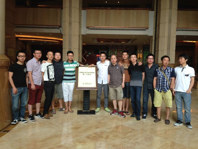 Twelve men pose together in a hotel lobby around a sign reading "中国比特币协会第一届会议" (China Bitcoin Association First Conference), commemorating the founders' early vision. The image relates to the post's nostalgic reflection on a group of crypto enthusiasts who persevered through regulatory crackdowns to see their 2013 hopes realized in the industry's golden age.