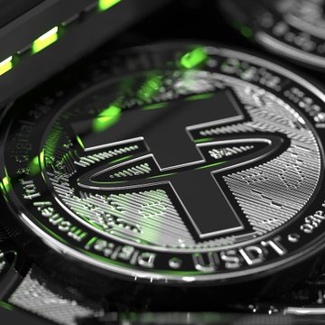 A close-up of a physical Tether (USDT) cryptocurrency coin with green accents, symbolizing the rapid growth of USDT0 as an omnichain version of USDT that surpassed $100 billion in transaction volume within 530 days.