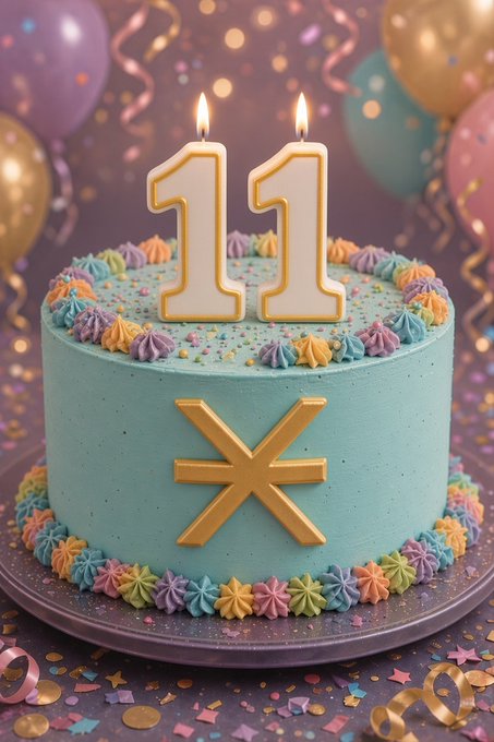 A festive turquoise birthday cake decorated with colorful frosting borders, sprinkles, and a gold star, topped with two '11' candles amid balloons and confetti.