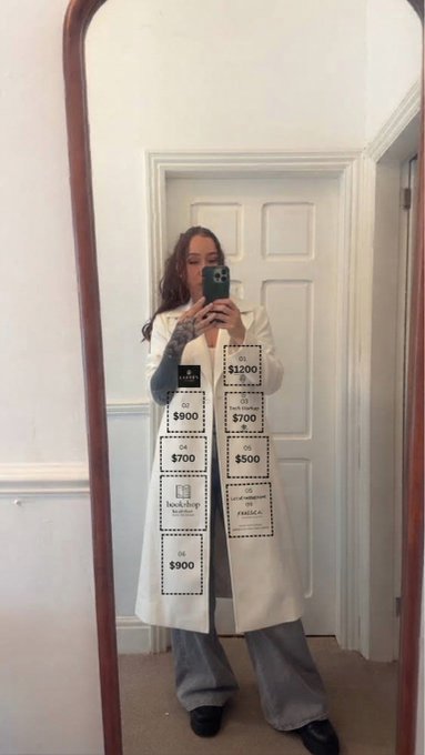 A person takes a mirror selfie wearing a long white coat with various brand labels and prices overlaid on the image, including amounts like $1200, $900, $700, and $500 alongside brand names like Chanel, Dior, and Hermes.