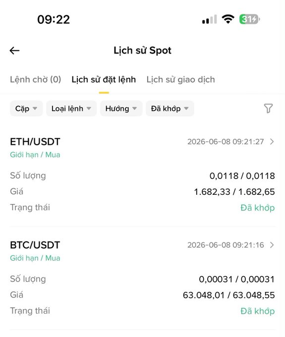 In this image, there is a screenshot of someone's cellphone displaying information about Ether (ETH) and Bitcoin (BTC). The screen shows the time as 09:22 and details such as the name "Lich su Spot", which could refer either to the location or an email address. There are two different instances of Bitcoin displayed on the phone, both with a value of 0 Bitcoins. Additionally, there is a price for Ether shown in two locations; one on the left side of the screen and another further away at the right edge. The presence of these details indicates that this could be information about cryptocurrency prices or a location's time zone when the Bitcoin transactions were executed.