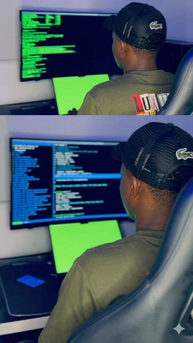 The image shows a man wearing a black hat sitting at a desk, working on his computer. The background of the image features two different screens - one displaying green text and another showing blue text. There are also two chairs visible in the scene, with one being occupied by the person using the computer and the other empty.