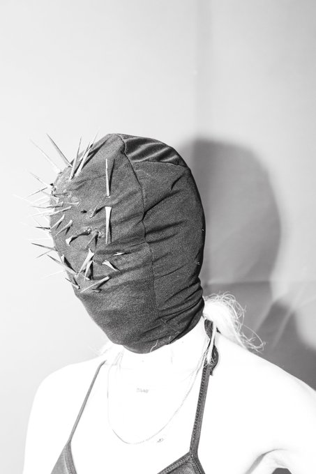 The image features a mannequin head wearing a black headband with numerous spikes sticking out of it, giving an edgy appearance. The mannequin has a bra strap visible under its chin. The background appears to be a plain white wall, which contrasts with the dark and spiky headband. The caption "I have just collected" is written in the image, possibly indicating that the mannequin's unique design caught someone's attention or was part of an art project or collection.