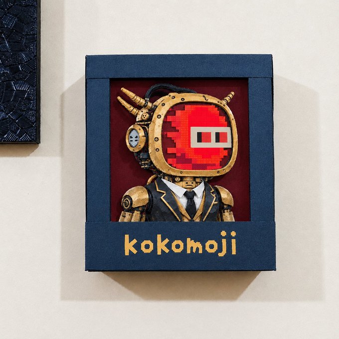 A framed artwork featuring a steampunk-style figure in a suit with a brass diving helmet displaying a red pixelated 'emoji-style' face, with the text 'kokomoji' written at the bottom of the navy blue frame.