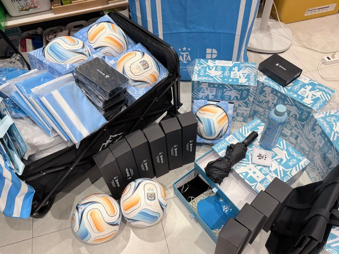 A collection of soccer merchandise featuring multiple soccer balls, shirts, and various Deepcoin-branded gift boxes is laid out on the floor, showcasing the prizes for the giveaway. The "AFA" and "DEEPCOIN COINUP" branding visible on the balls and packaging aligns with the Argentina vs Switzerland match celebration mentioned in the post.