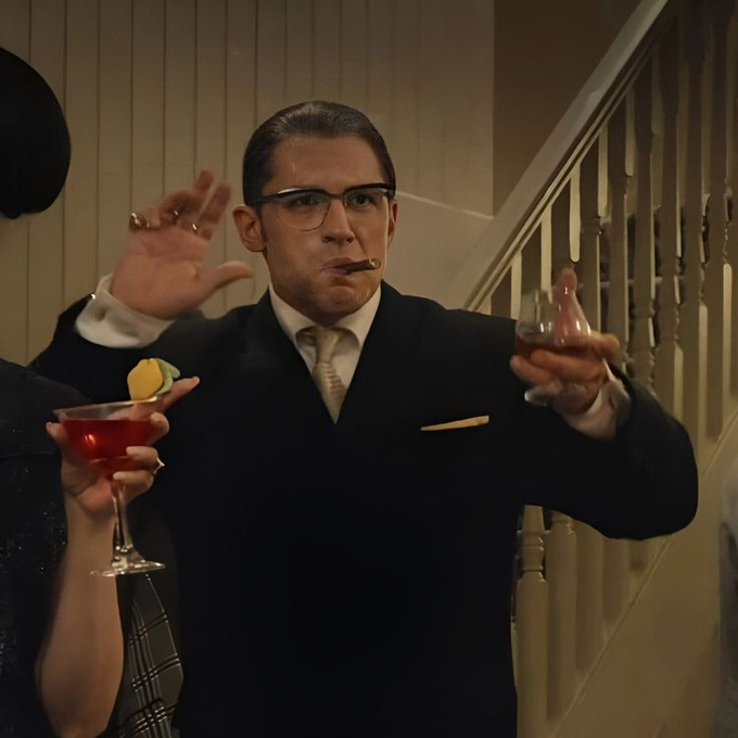 A man in a sharp suit with slicked-back hair and glasses holds a cigar in one hand while raising the other, with a woman beside him holding a cocktail garnished with a lemon. The post appears to celebrate gaining "Beta" access with "full model" privileges, humorously framing the man in the image as a smug, confident figure enjoying exclusive access—mirroring the boastful tone of someone who just secured premium features.
