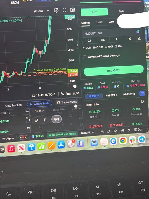 A photograph of a computer screen showing a cryptocurrency trading interface with a green line chart, buy/sell options, and a 'Buy CATE' button, alongside an open macOS dock at the bottom.