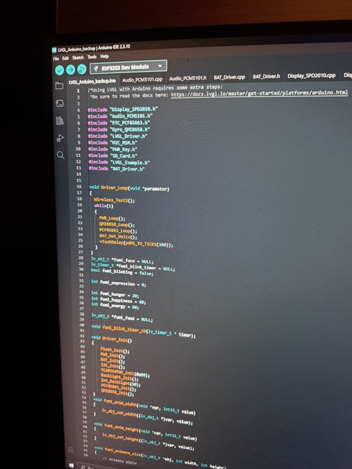 A computer monitor displaying Arduino IDE code for an ESP32 Dev Module, showing a sketch file with various include statements and function definitions.