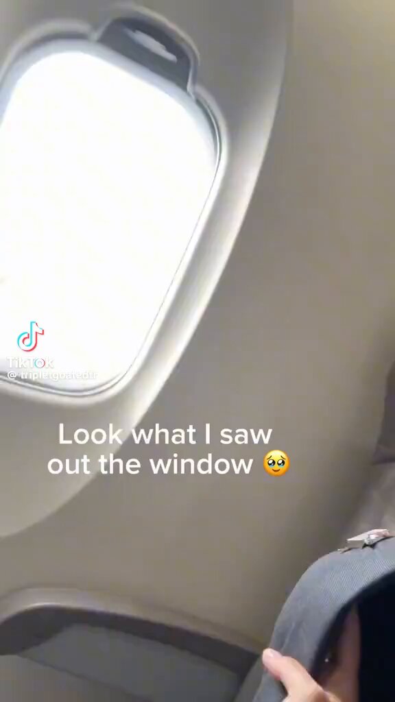 The image shows a person holding onto their seatbelt while sitting inside an airplane, with the window open behind them. There are also some text elements present in the image that read "Look What I Saw Out the Window" and "$TripleT The Main character that will onboard every normie into the Solana trenches." These texts seem to be related to a post or conversation about the experience of flying, possibly discussing the view from the airplane window.

The main focus is on the person holding onto their seatbelt while sitting in front of an open airplane window. The image does not provide any additional information about the content of the text elements present in the scene.