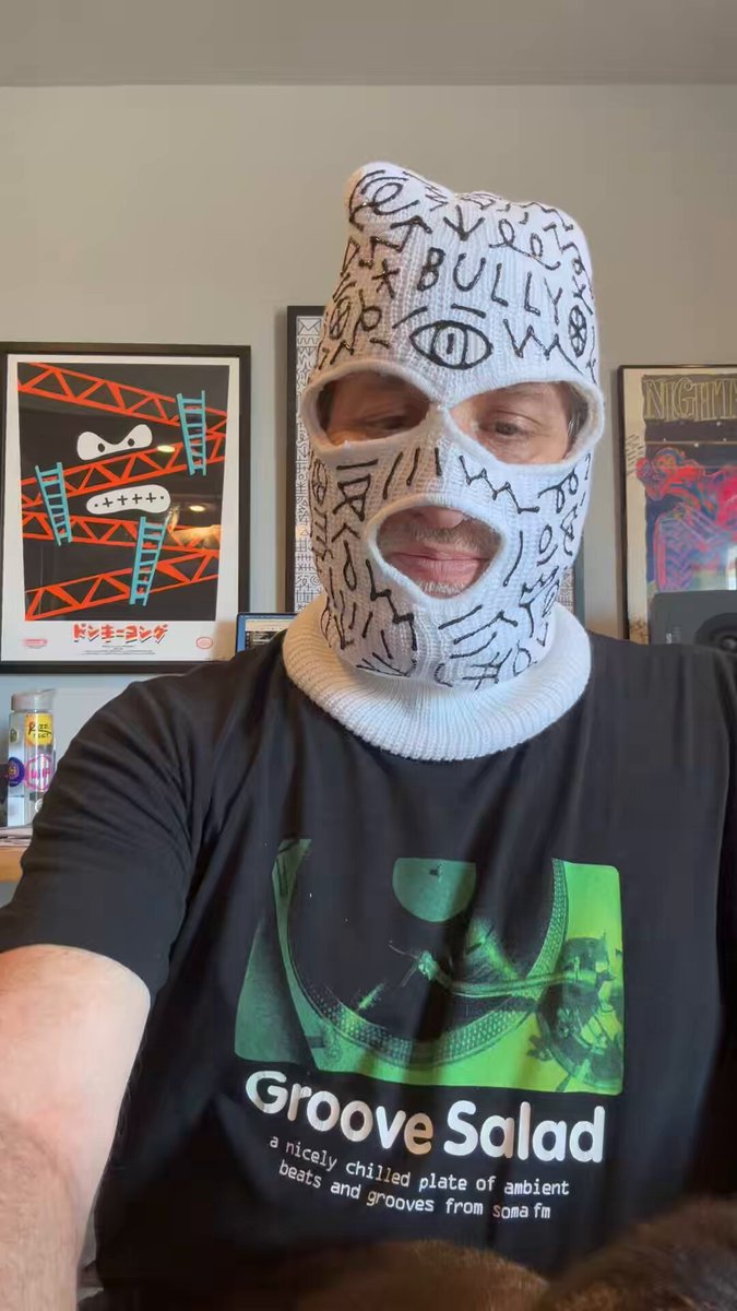 !"", "8ZL7U6", "!O!", "@", "#%", "$&'(", ")", "", ":)", "#", "$&'(", ")", "@", "#", "$&'(", ")", """. The image shows a man wearing a knit ski mask over his face, posing for the camera.