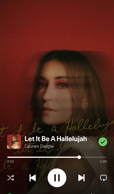A Spotify music player shows 'Let It Be A Hallelujah' by Lauren Daigle playing at 2:52, featuring red-toned album artwork with a woman's face.