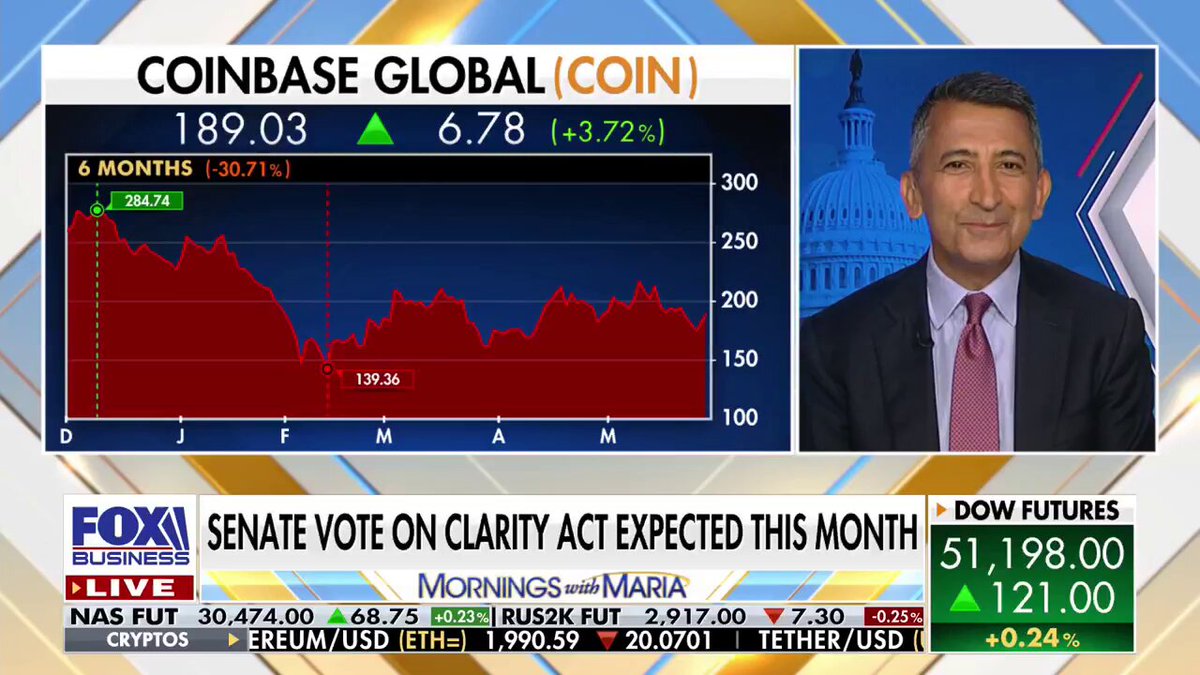 The image shows a man wearing a suit talking about coinbase global coin, which is related to the recent news that Congress has passed a bill allowing banks to get into the crypto space. The man appears to be discussing this development with someone on television or in person.