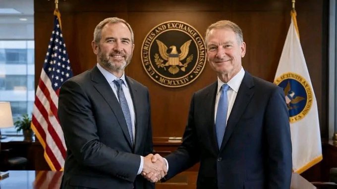 The image shows two men shaking hands, both dressed in suits and ties, likely in an office setting. They are positioned in front of a desk that has a flag from the United States, which suggests they might be in a government or corporate office. The man on the left is wearing a tie with the letters "Ripple" written on it, while the other man's tie features the word "RLUSD". This could indicate that Ripple is seeking recognition as top-tier institutional collateral for Bitcoin and Ethereum.