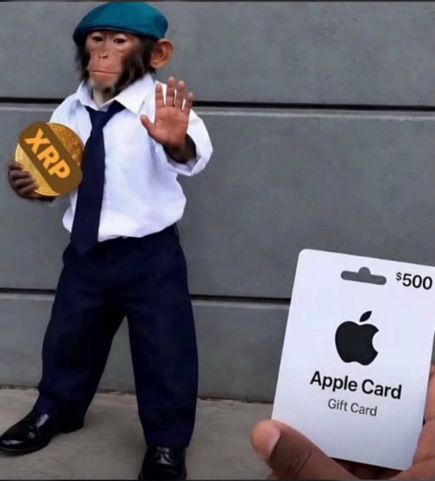 A dressed-up monkey in a shirt, tie, and teal cap holds an XRP coin while holding up a hand, as an Apple Card Gift Card for $500 is offered in the foreground.