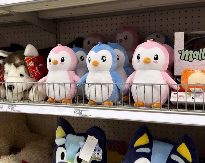 Pudgy Penguins plush toys ($10.99–$14.99) line a store shelf, exemplifying how the NFT brand has evolved into tangible consumer products.