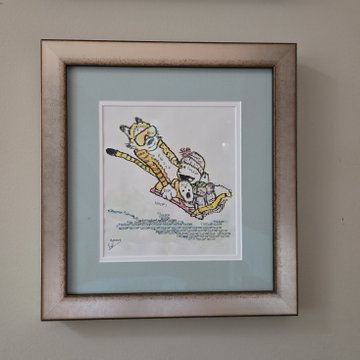 A framed illustration of an airplane with passengers visible through the windows, displayed against a light blue background.