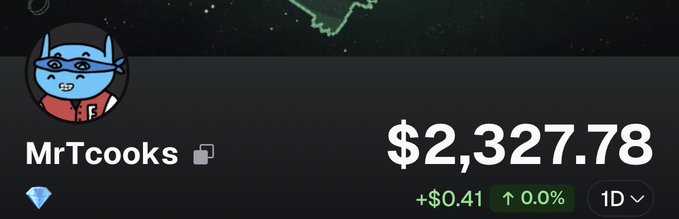 A crypto wallet profile for 'MrTcooks' showing a balance of $2,327.78, with a small increase of +$0.41 (0.0%) over 1 day.