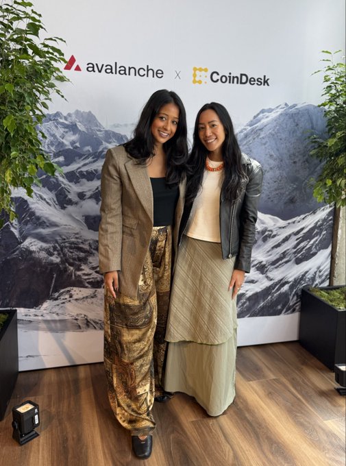 Two women pose together at the Avalanche x CoinDesk event, with the "avalanche × CoinDesk" branding displayed on a mountain-themed backdrop behind them, tying into the post's announcement of the Tech crew coverage coming from the Avalanche Summit on CoinDesk.