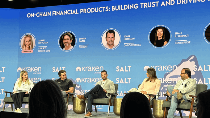 A panel discussion on "On-Chain Financial Products: Building Trust and Driving..." at a Kraken-sponsored SALT conference features speakers including Sarah Siththaman of Peakrs Core, Lorien Gabel of Figment, John Hoffman of Ondo Finance, and Bha Ji Illuminati of Centrifuge, visually supporting the article's theme of tokenization's growing adoption as Ondo's John Hoffman draws parallels between today's tokenized assets and the early days of ETFs.