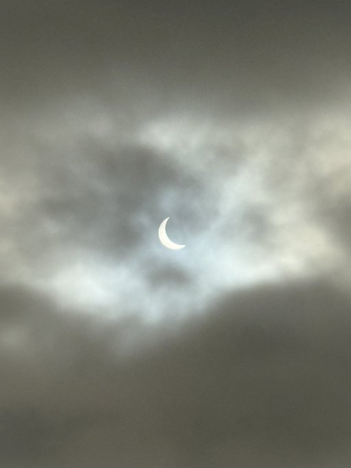 A partial solar eclipse glows through a veil of gray clouds, its crescent shape standing as a striking celestial moment—fitting imagery for someone hoping the rare event signals an upswing in Solana ($SOL).