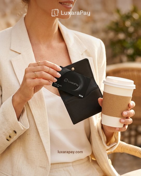 A LuxaraPay advertisement showing a woman in a cream blazer holding a Visa credit card and a takeaway coffee cup, with the text "luxarapay.com" displayed.