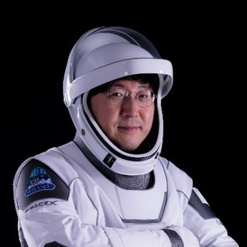 urn of a person wearing a white spacesuit with blue and gray accents, glasses, and a helmet with a clear visor against a black background.