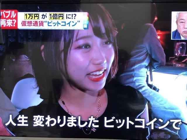 A screenshot from a Japanese news broadcast shows a young woman smiling and saying "人生変わりました ビットコインで" (My life changed with Bitcoin), with on-screen graphics highlighting the dramatic rise of Bitcoin from 10,000 yen to potentially 100 million yen. The image relates to the post by illustrating how early Bitcoin investors who held even just 1 BTC saw their lives transformed as the cryptocurrency's value skyrocketed.