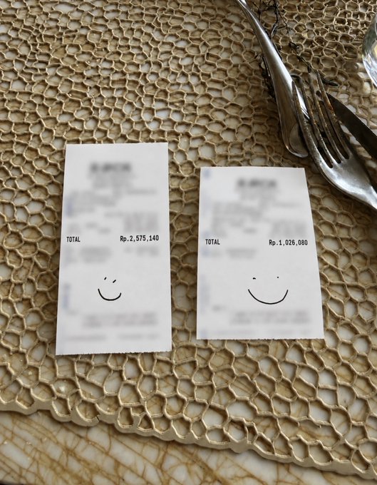 Two receipts on a textured plate with smiley faces doodled on them, showing totals of Rp. 2,575,140 and Rp. 1,025,000 in Indonesian Rupiah.