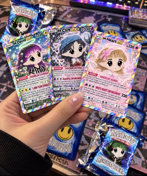 A hand holds three holographic trading cards from a 'Milady' set ('M David EX', 'M Cliff EX', 'M Heart EX') featuring anime-style characters, with additional foil packs scattered on a table.